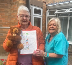 Our 'Name the Bear' competition winner Pauline holding "Molly" the teddy bear with Marie who sold the names 