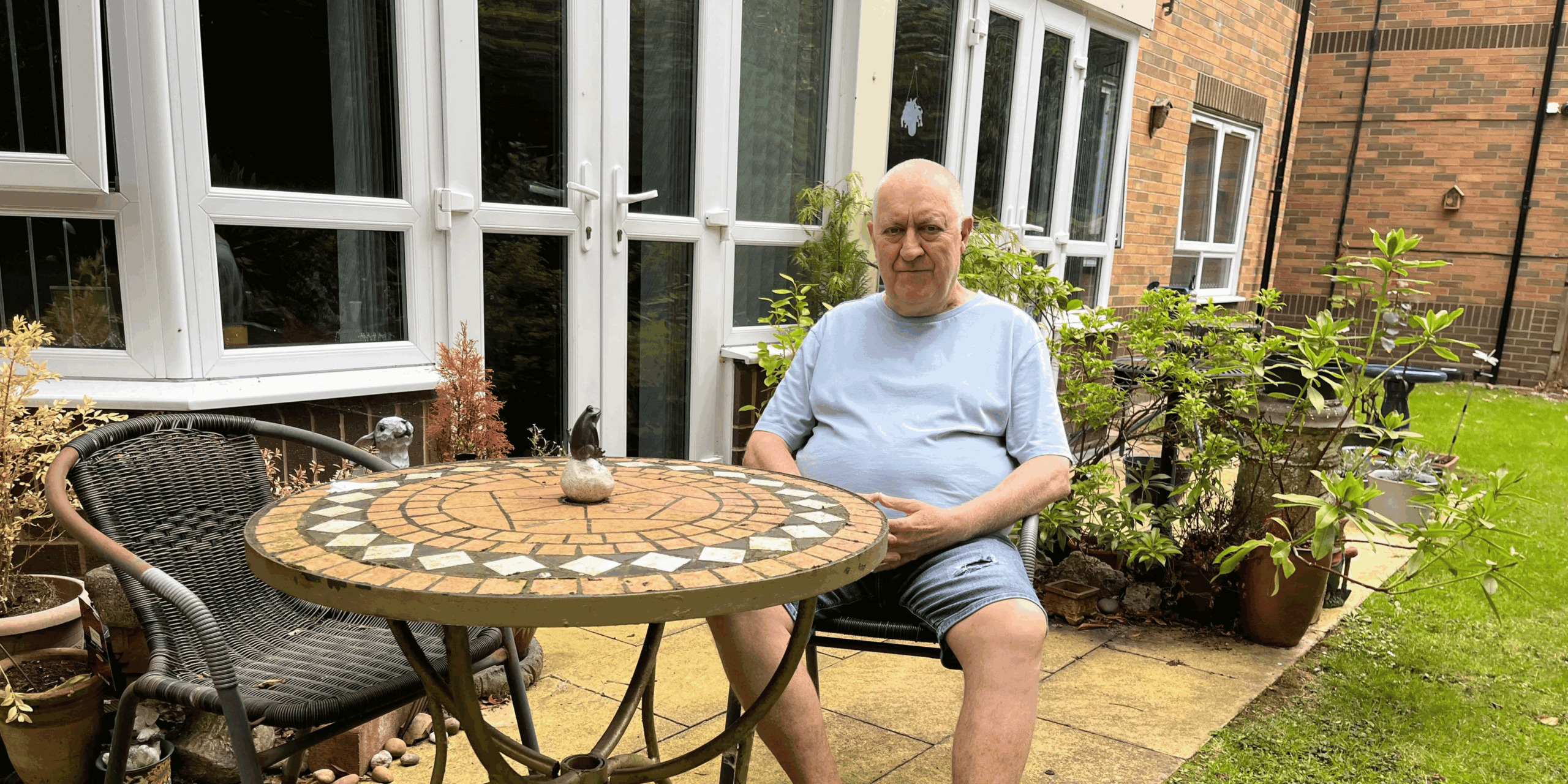 Ian Raid, resident at Whitley Court, sitting int eh garden