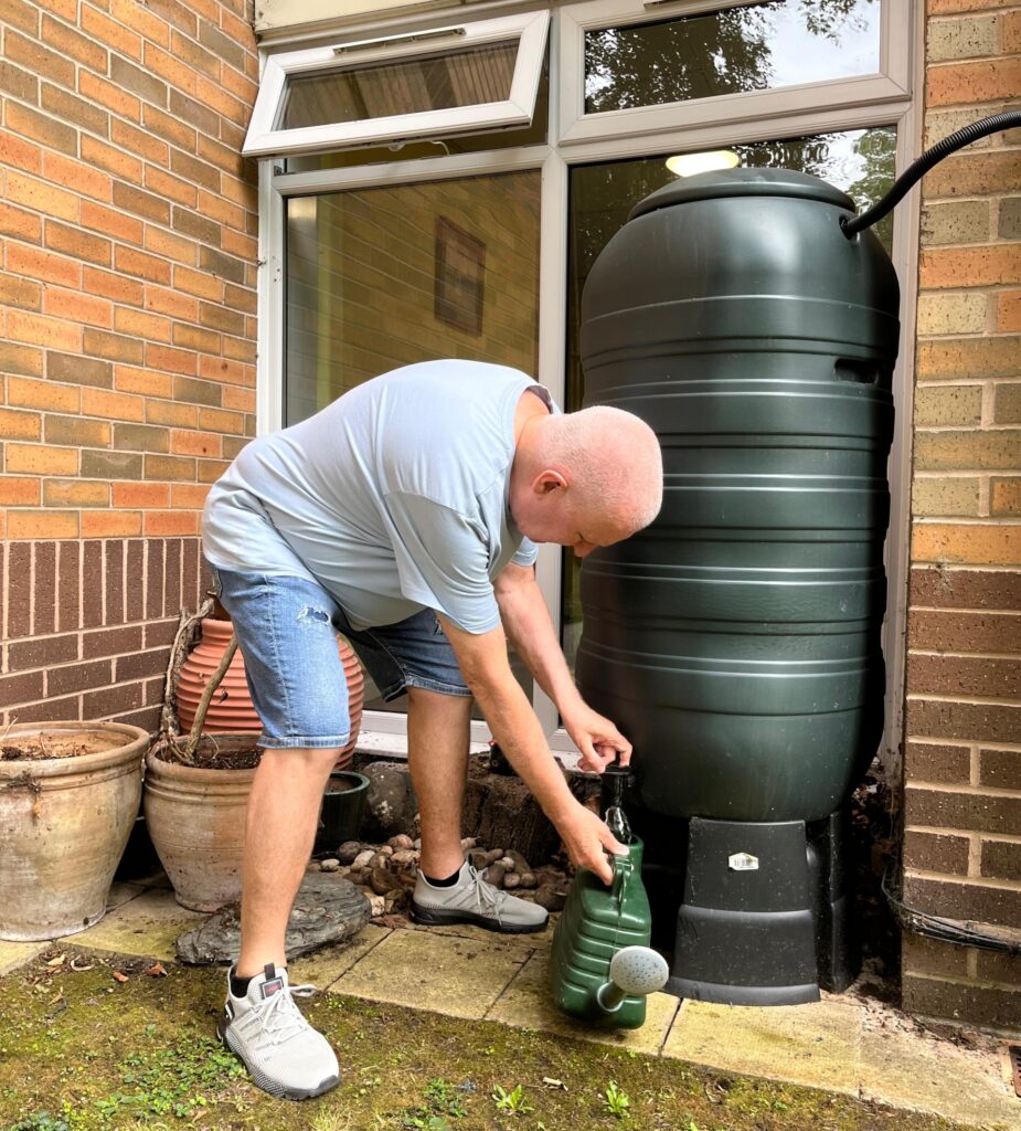 Ian Raid, resident at Whitley Court, using the water butts he installed