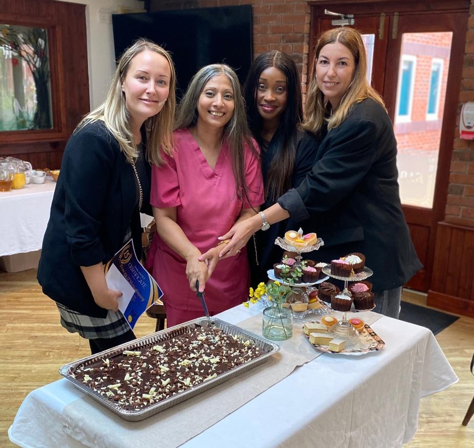 Tracey, Sulender,Sainabou and Veronica cutting a cake to celebrate their long service awards at Neville Williams House in September 2025