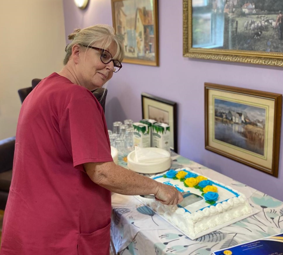 Noreen cutting the cake at Robert Harvey House long service awards