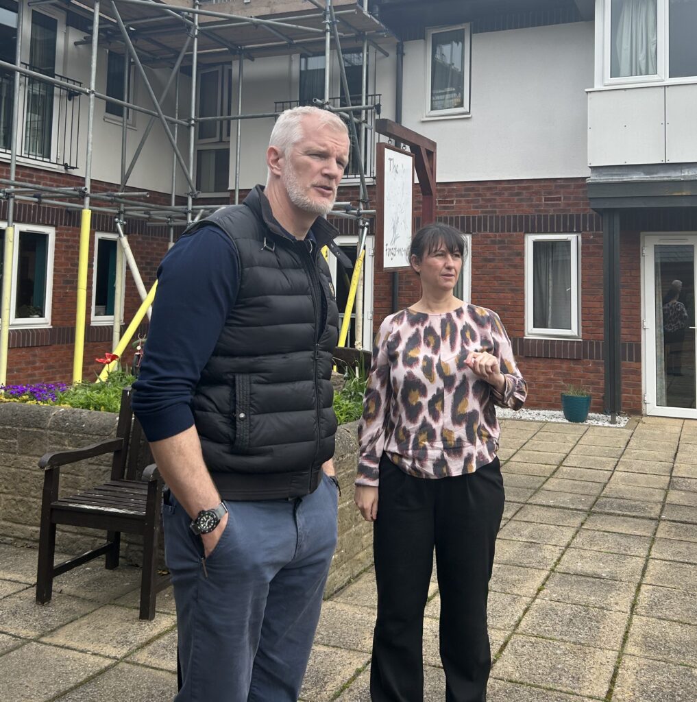 MP Al Carns and home manager Amy Beasley tour the gardens at Neville Williams House where are new sensory street is to be built